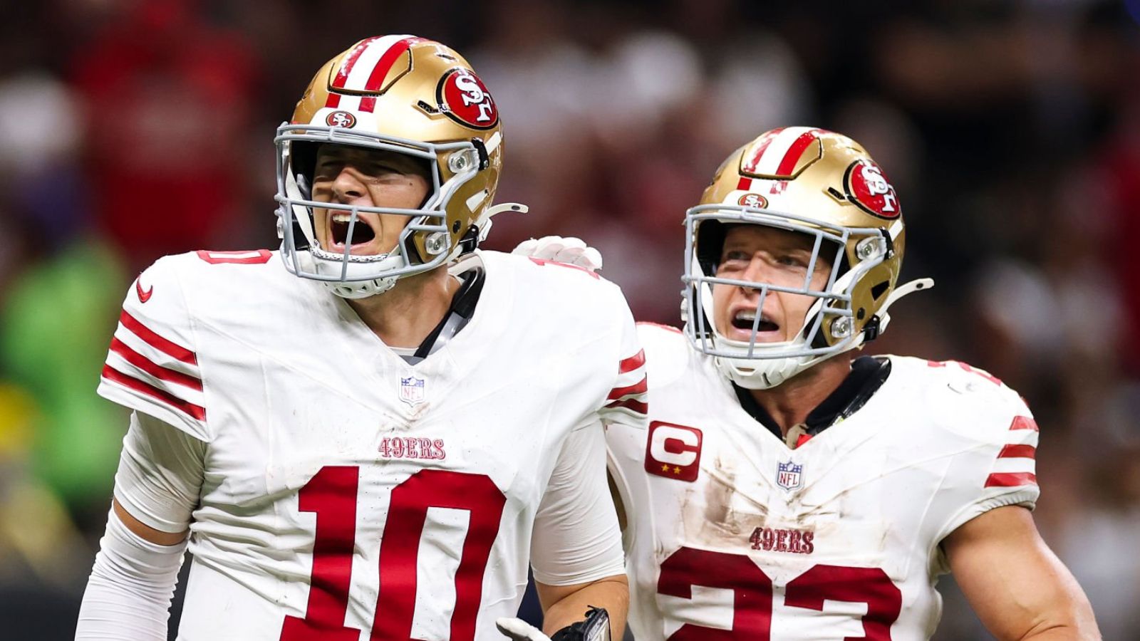 QB Mac Jones y RB Christian McCaffrey. Foto: Sean Gardner/Getty Images