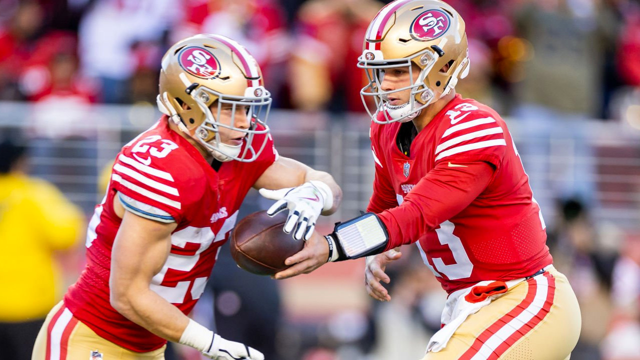 Christian McCaffrey, RB de los 49ers recibiendo el balón de Brock Purdy, QB de los 49ers