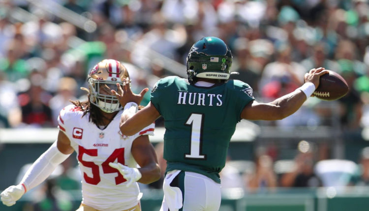 Fred Warner, LB de los 49ers (izquierda), Jalen Hurts, QB de los Eagles (centro)